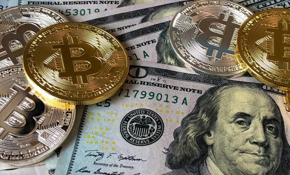 pexels-photo-730547-730547 A close-up photo depicting Bitcoin coins on top of US dollar bills, symbolizing finance and cryptocurrency.